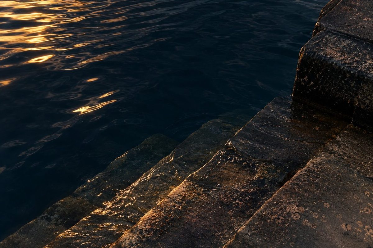 A tide line on a harbour wall marking the high and low water points